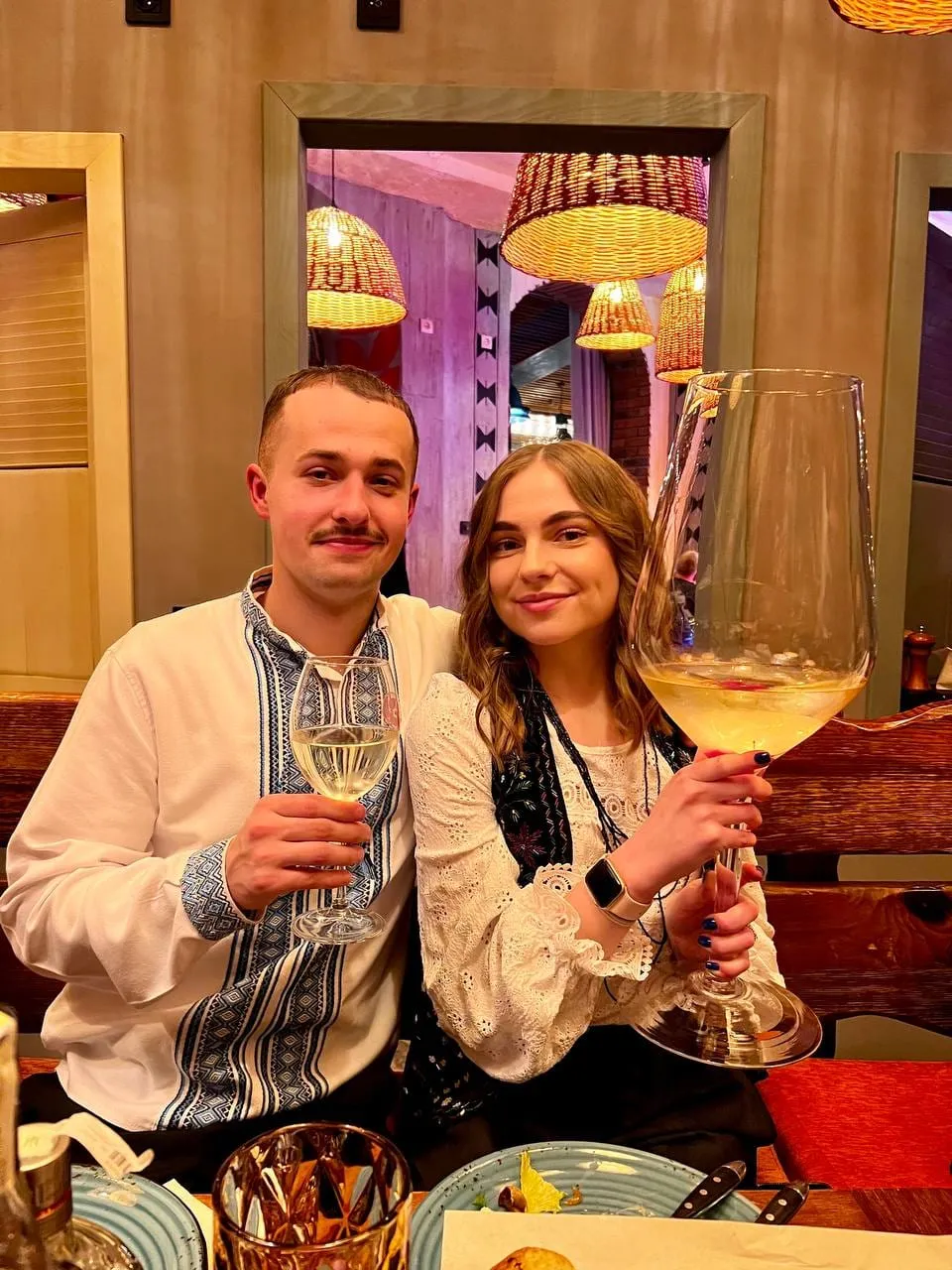 Пара з великим келихом вина за столом